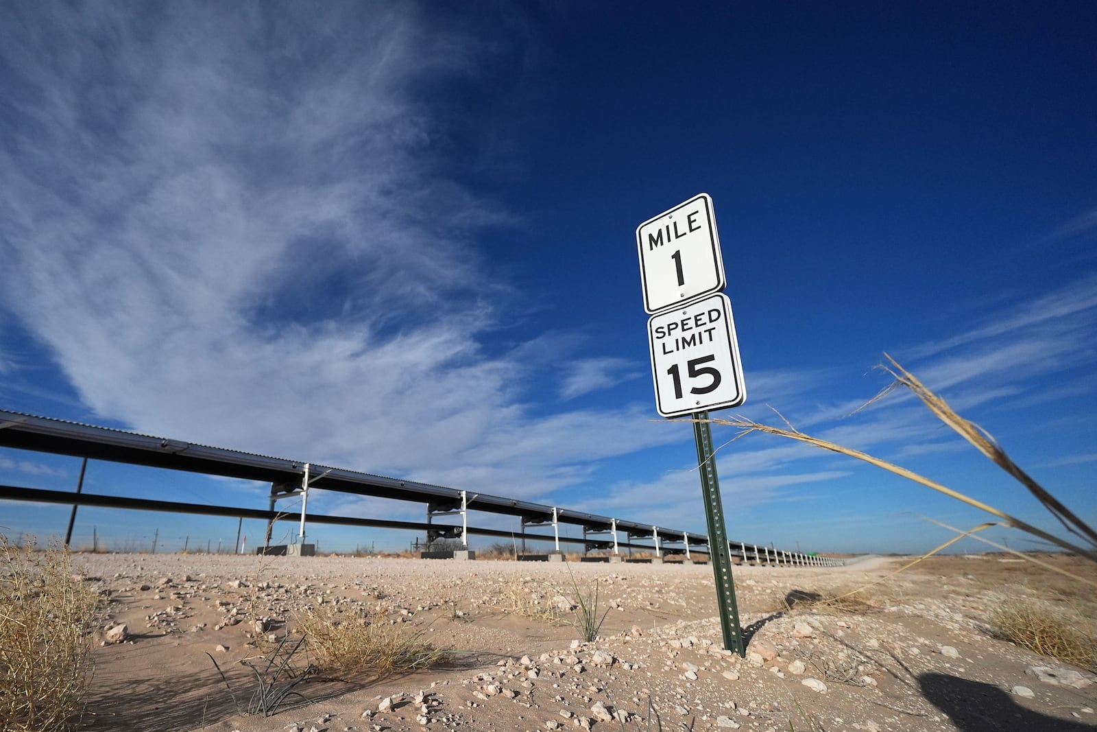 A sign displays the first mile of a 42-mile conveyor belt by Atlas Energy that carries sand needed for hydraulic fracturing Wednesday, Feb. 26, 2025, in Kermit, Texas. (AP Photo/Julio Cortez)