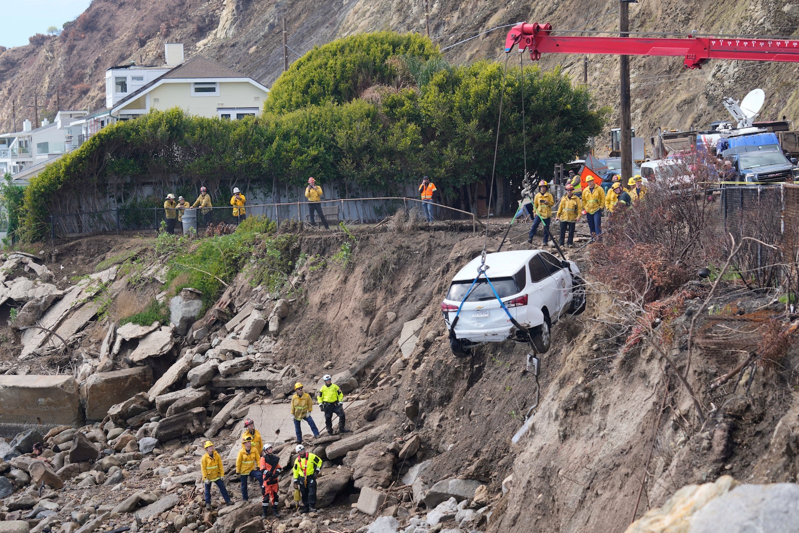 An emergency vehicle is pulled out of the water a day after it was pushed into the surf by a debris flow caused by heavy rainfall, Friday, Feb. 14, 2025, in Malibu, Calif. (AP Photo/Damian Dovarganes)