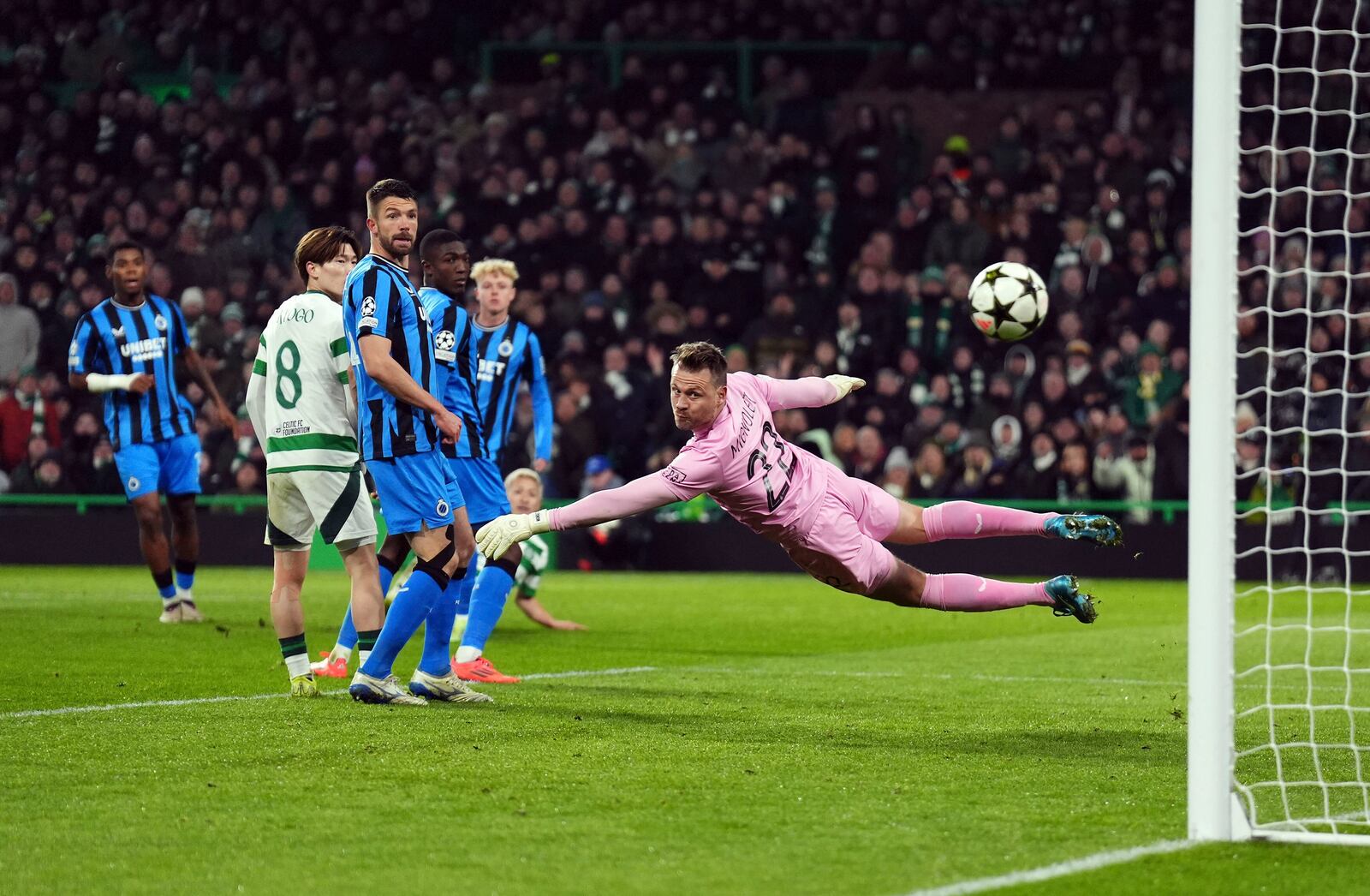 Celtic's Daizen Maeda scores past Club Brugge goalkeeper Simon Mignolet during the UEFA Champions League opening phase soccer stage match at Celtic Park, Glasgow, Scotland, Wednesday Nov. 27, 2024. (Andrew Milligan/PA via AP)