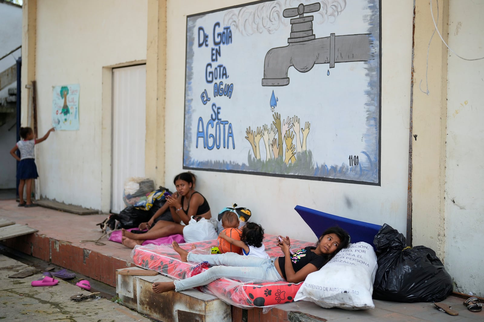 People displaced by guerrilla attacks that have killed dozens and forced thousands to flee their homes, gather at a school serving as a temporary shelter in Tibu, Colombia, Tuesday, Jan. 21, 2025. (AP Photo/Fernando Vergara)