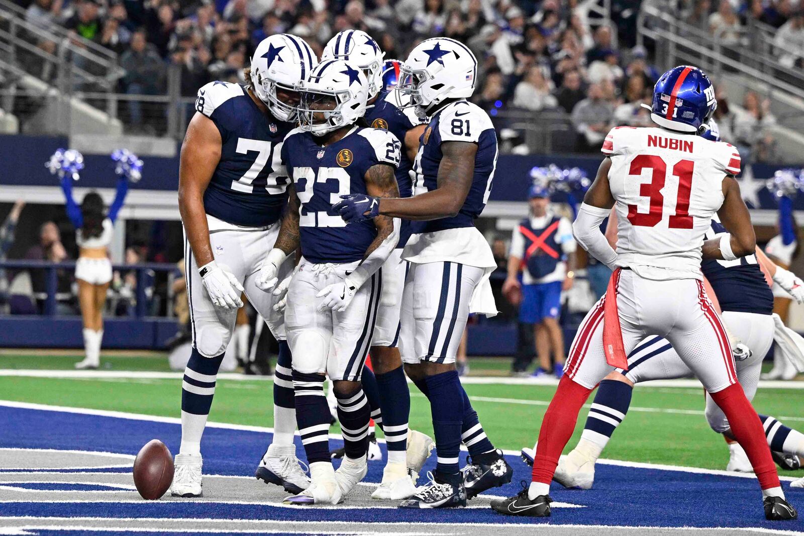 Dallas Cowboys running back Rico Dowdle (23) is surrounded by teammates after scoring a touchdown against the New York Giants during the second half of an NFL football game in Arlington, Texas, Thursday, Nov. 28, 2024. (AP Photo/Jerome Miron)