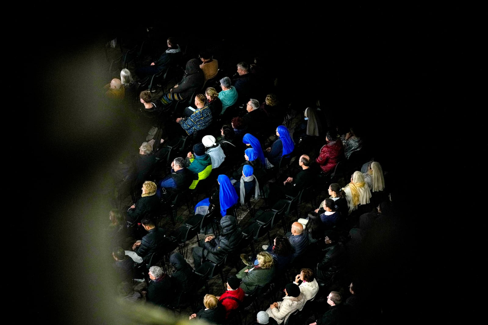 People attend a rosary prayer with Cardinal Victor Manuel Fernandez held for the health of Pope Francis in St Peter's Square at the Vatican, Friday, Feb. 28, 2025. (AP Photo/Andrew Medichini)