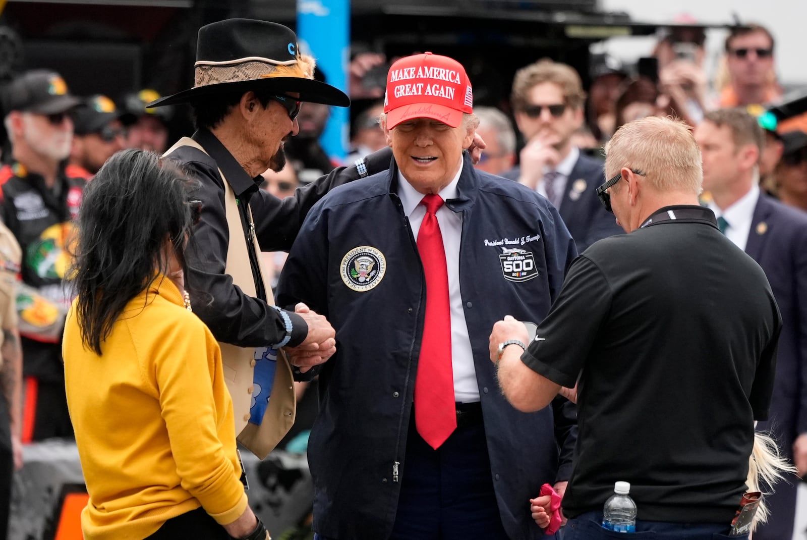 President Donald Trump, second right, shakes hands with NASCAR Hall of Fame driver Richard Petty at the NASCAR Daytona 500 auto race at Daytona International Speedway, Sunday, Feb. 16, 2025, in Daytona Beach, Fla. (AP Photo/John Raoux)