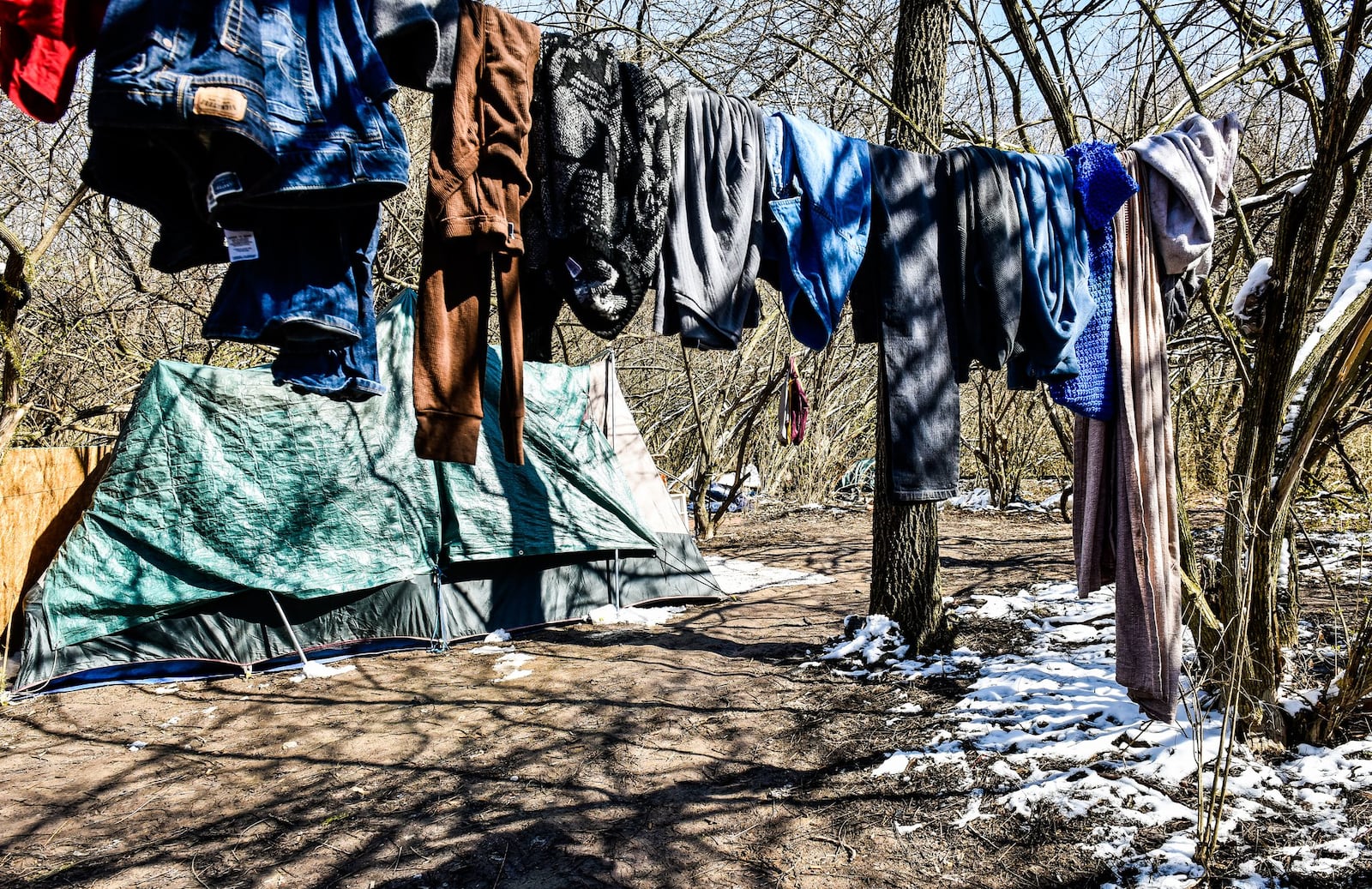 Tents are set up in a homeless camp behind Hamilton Plaza shopping center Thursday, March 22. NICK GRAHAM/STAFF