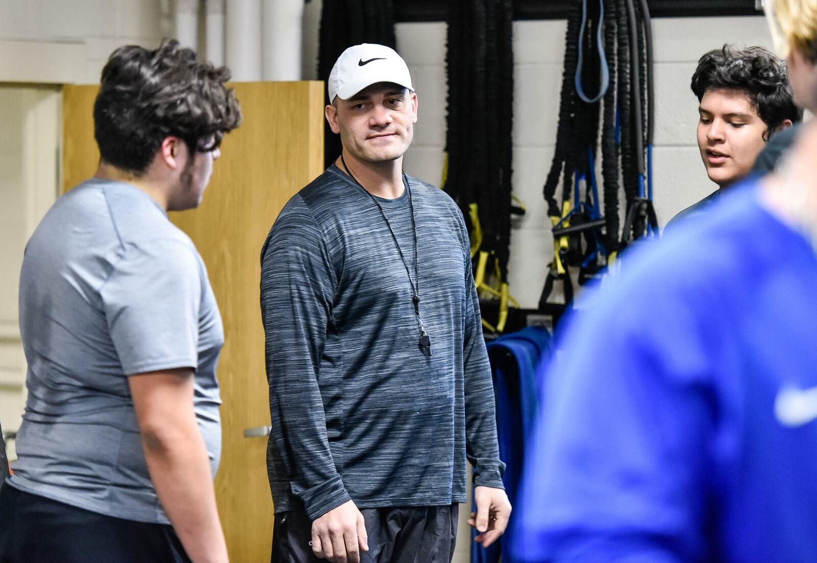 New Hamilton football coach Nate Mahon listens to his players during a Thursday weight lifting session at the school. NICK GRAHAM/STAFF