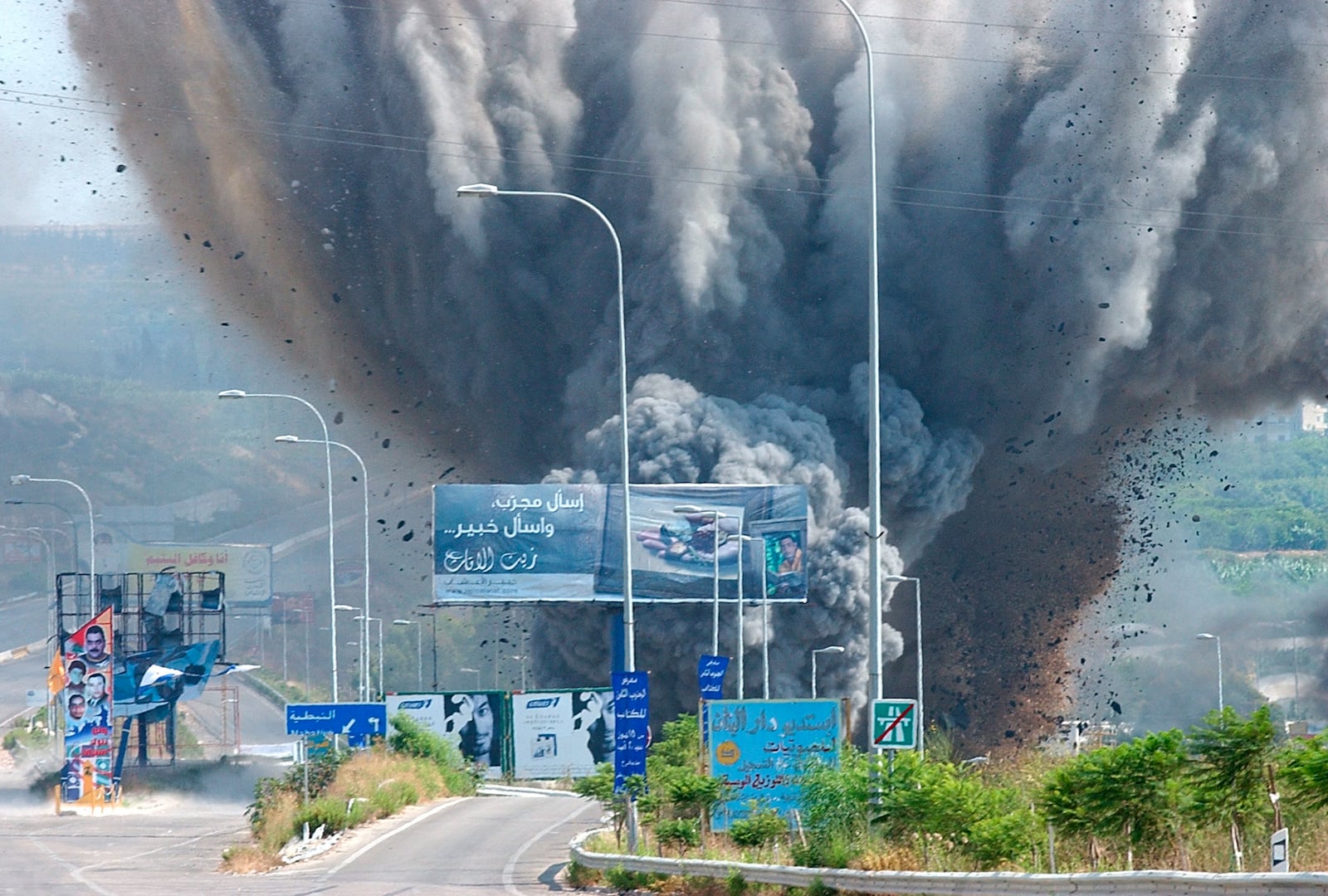 FILE - Smoke rises and debris flies from a bridge as it is targeted by an Israeli air raid, in the Zahrani region, on the Mediterranean coast, southern Lebanon, on July 14, 2006. (AP Photo/Mohammed Zaatari, File)