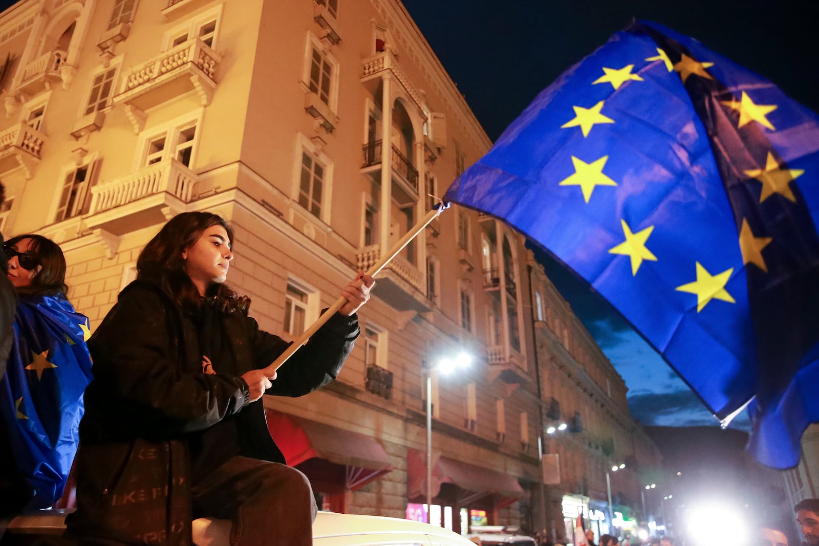 A protester waves an EU flag as she takes part in a rally against alleged violations in a recent parliamentary election in Tbilisi, Georgia, Monday, Nov. 4, 2024. (AP Photo/Zurab Tsertsvadze)