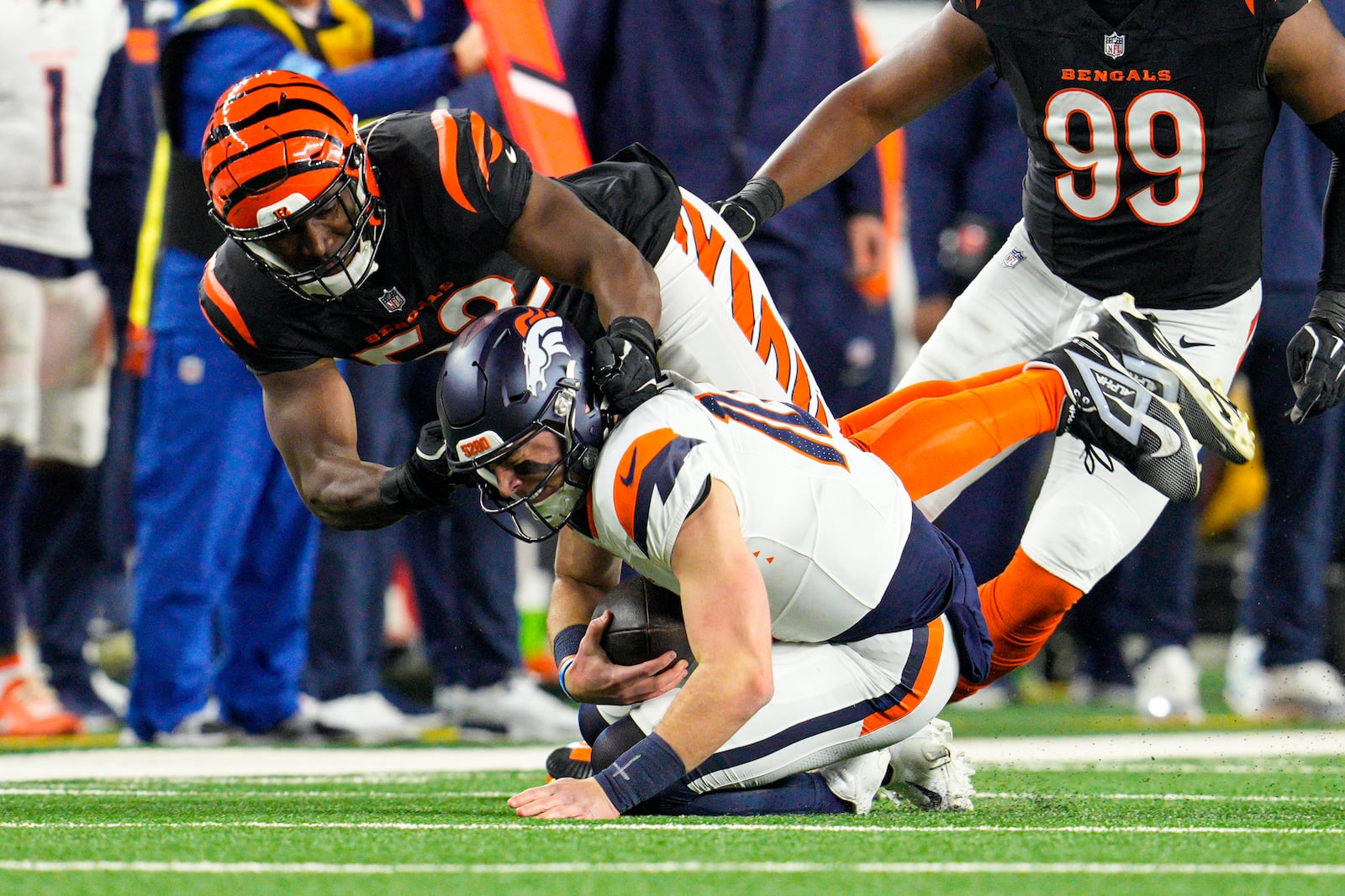 Cincinnati Bengals defensive end Cedric Johnson (52) sacks Denver Broncos quarterback Bo Nix (10) during the first half of an NFL football game in Cincinnati, Saturday, Dec. 28, 2024. (AP Photo/Jeff Dean)