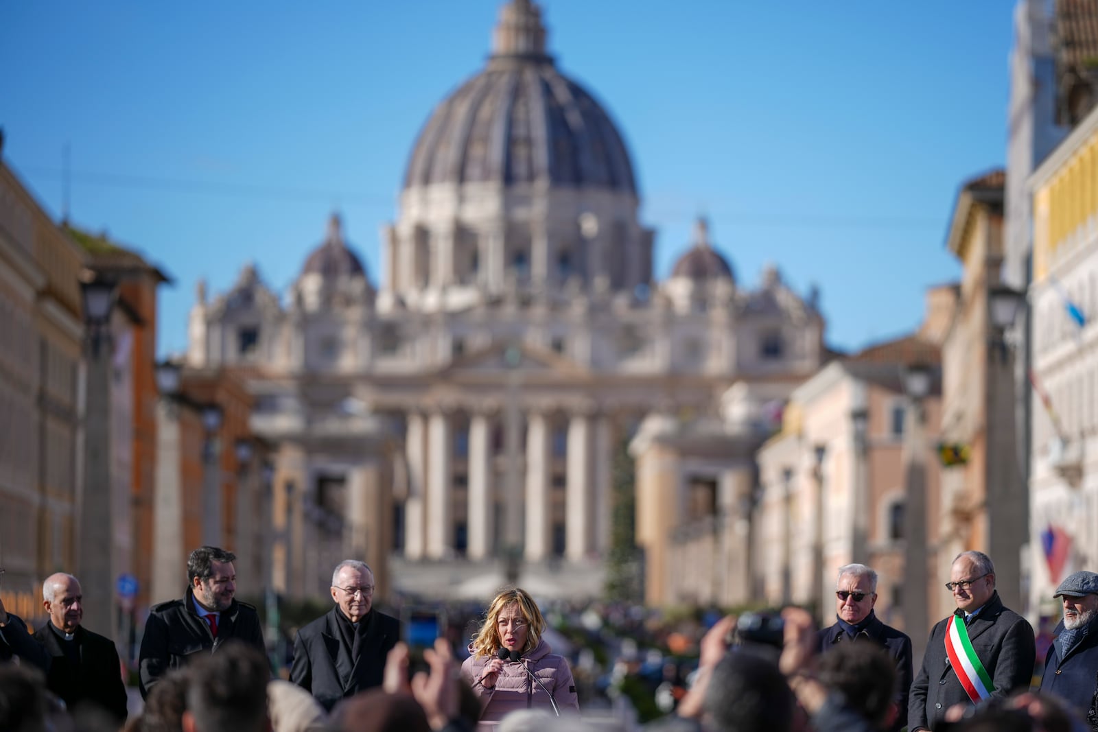 Italian Premier Giorgia Meloni, center, backdropped by St.Peter's Basilica, delivers her speech in Rome, Italy, Monday, Dec. 23, 2024 during the opening ceremony of a new pedestrian area in the nearby of the Vatican, just ahead of the Jubilee Year, an event expected to draw millions of visitors to the Eternal City. (AP Photo/Andrew Medichini)