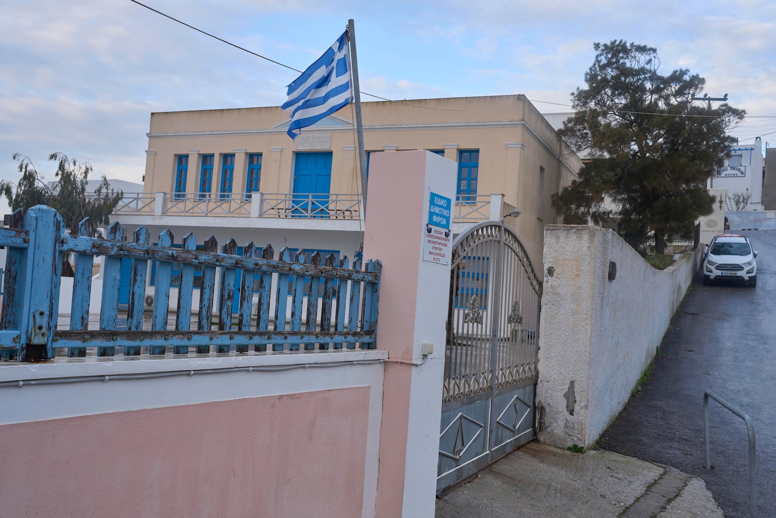 A Greek flag waves at a closed primary school due the situation as Greek authorities are taking emergency measures in response to intense seismic activity on the popular Aegean Sea holiday island of Santorini, southern Greece, Monday, Feb. 3, 2025.(AP Photo/Petros Giannakouris)