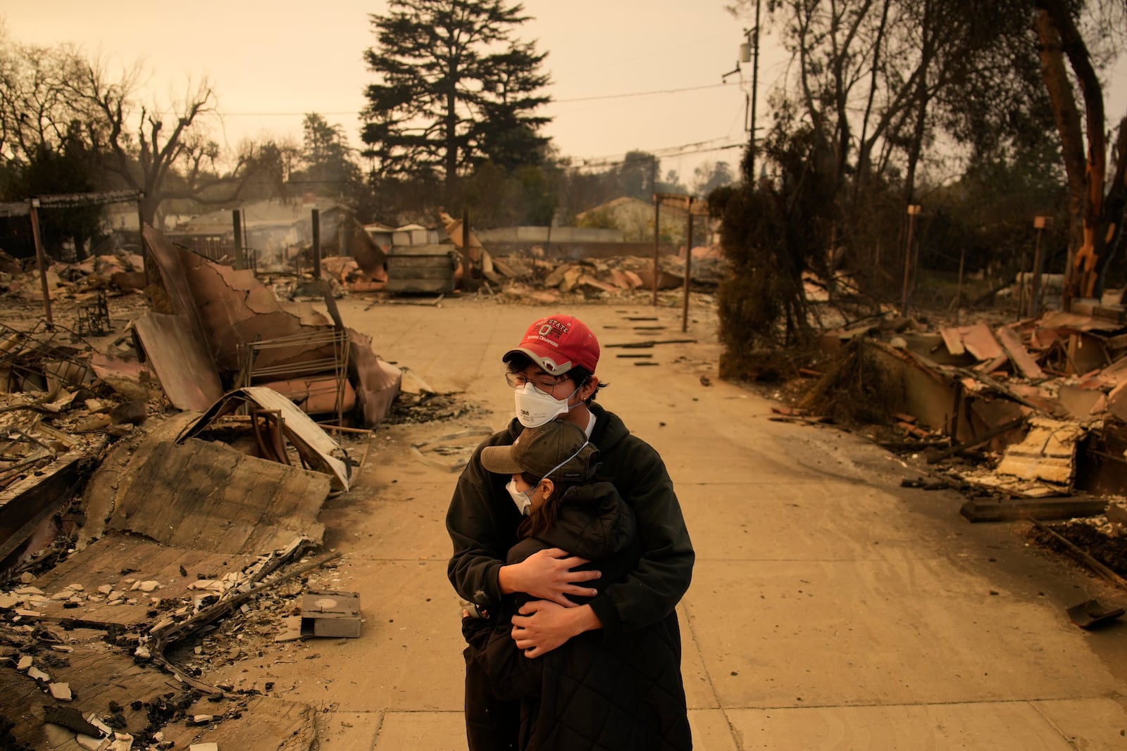 A man and woman hold each other in the rubble of destroyed homes in Altadena, Calif., Thursday, Jan. 9, 2024. (AP Photo/John Locher)