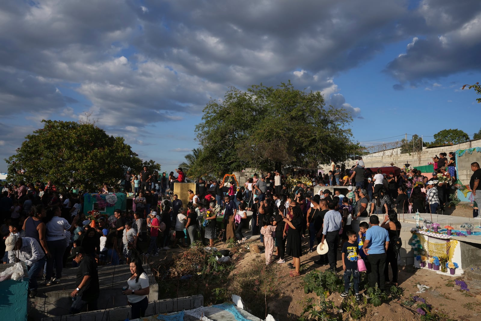 Mourners attend the burial ceremony for victims of a bus crash at the cemetery in Santo Domingo Los Ocotes, Guatemala, Tuesday, Feb. 11, 2025. Dozens of passengers died after their bus plunged into a gorge and landed under a bridge on Feb. 10 on the outskirts of the Guatemalan capital. (AP Photo/Moises Castillo)