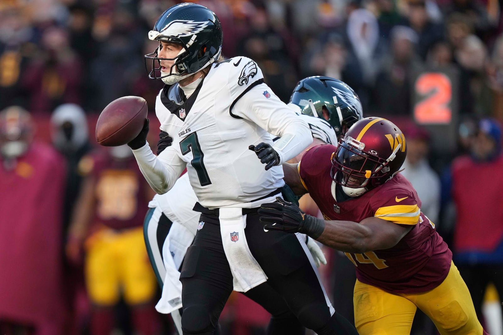 Philadelphia Eagles quarterback Kenny Pickett (7) avoids a tackle by Washington Commanders linebacker Bobby Wagner (54) during the second half of an NFL football game, Sunday, Dec. 22, 2024, in Landover, Md. (AP Photo/Stephanie Scarbrough)