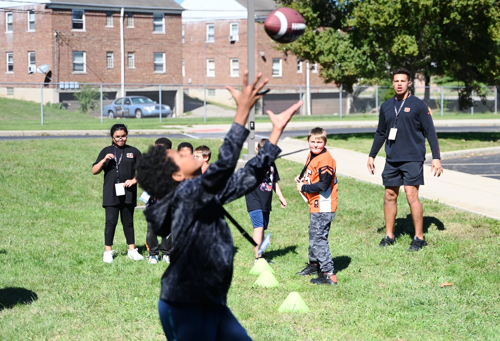 Just a Pair of Shoes, a nonprofit organization that distributes free high-end shoes distributed 120 pairs to students at Highland Elementary School in the Hamilton City School District. The event was sponsored by Kettering Health and the Cincinnati Bengals. After receiving the shoes, the students put them on and tried them out. Pictured is Bengals tight end, and Fairfield High School graduate, Eric All Jr. passing a ball to a student just outside the gym of the elementary school. MICHAEL D. PITMAN/STAFF