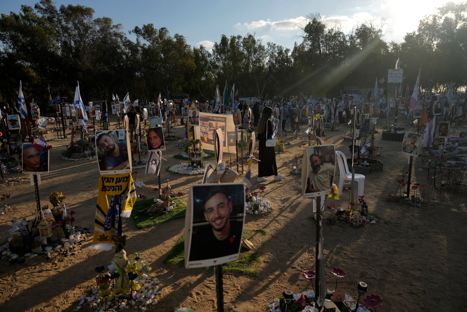 FILE - People visit the site of the Nova music festival, where hundreds of revelers were killed and abducted by Hamas and taken into Gaza, on the one-year anniversary of the attack near Kibbutz Reim, southern Israel, on Oct. 7, 2024. (AP Photo/Ariel Schalit, File)