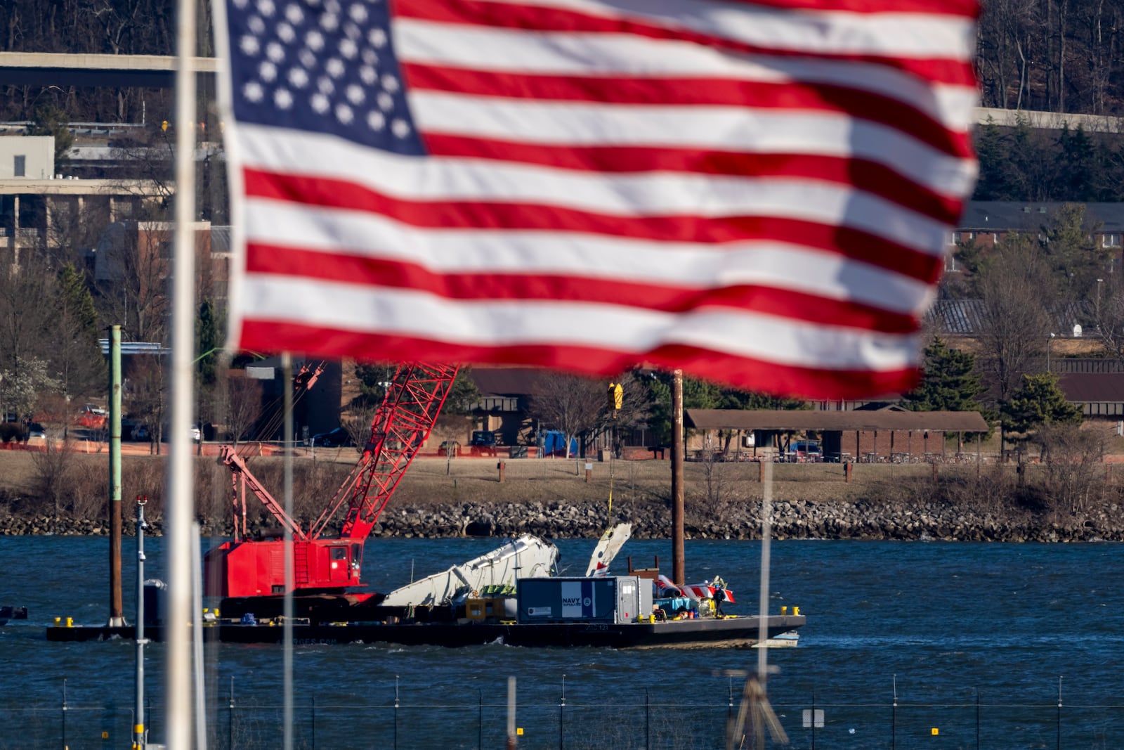 A piece of wreckage is lifted from the water onto a salvage vessel, near the site in the Potomac River of a mid-air collision between an American Airlines jet and a Black Hawk helicopter, at Ronald Reagan Washington National Airport, Tuesday, Feb. 4, 2025, in Arlington, Va. (AP Photo/Ben Curtis)