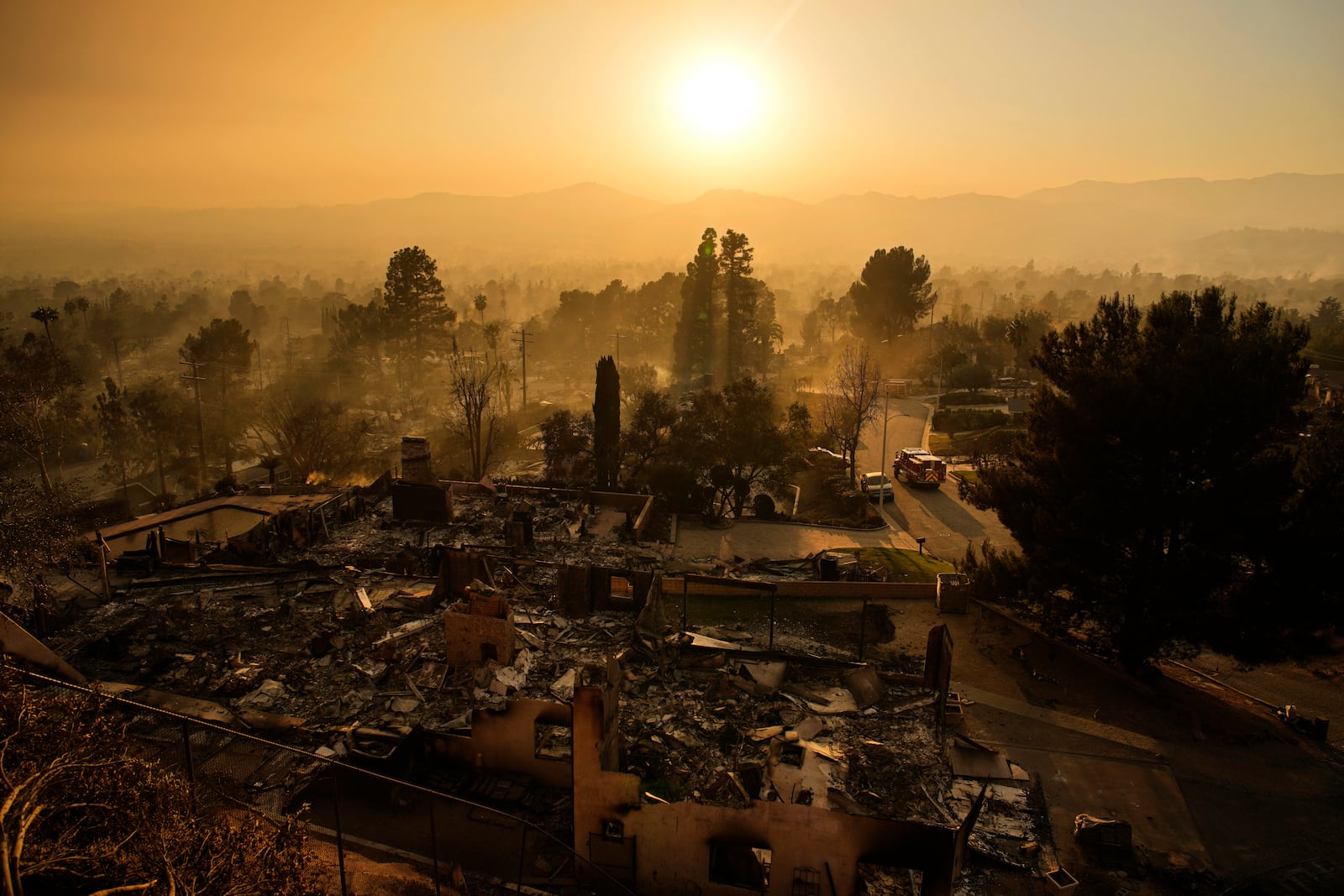 An emergency vehicle drives through a neighborhood devastated by the Eaton Fire, Thursday, Jan. 9, 2025, in Altadena, Calif. (AP Photo/John Locher)