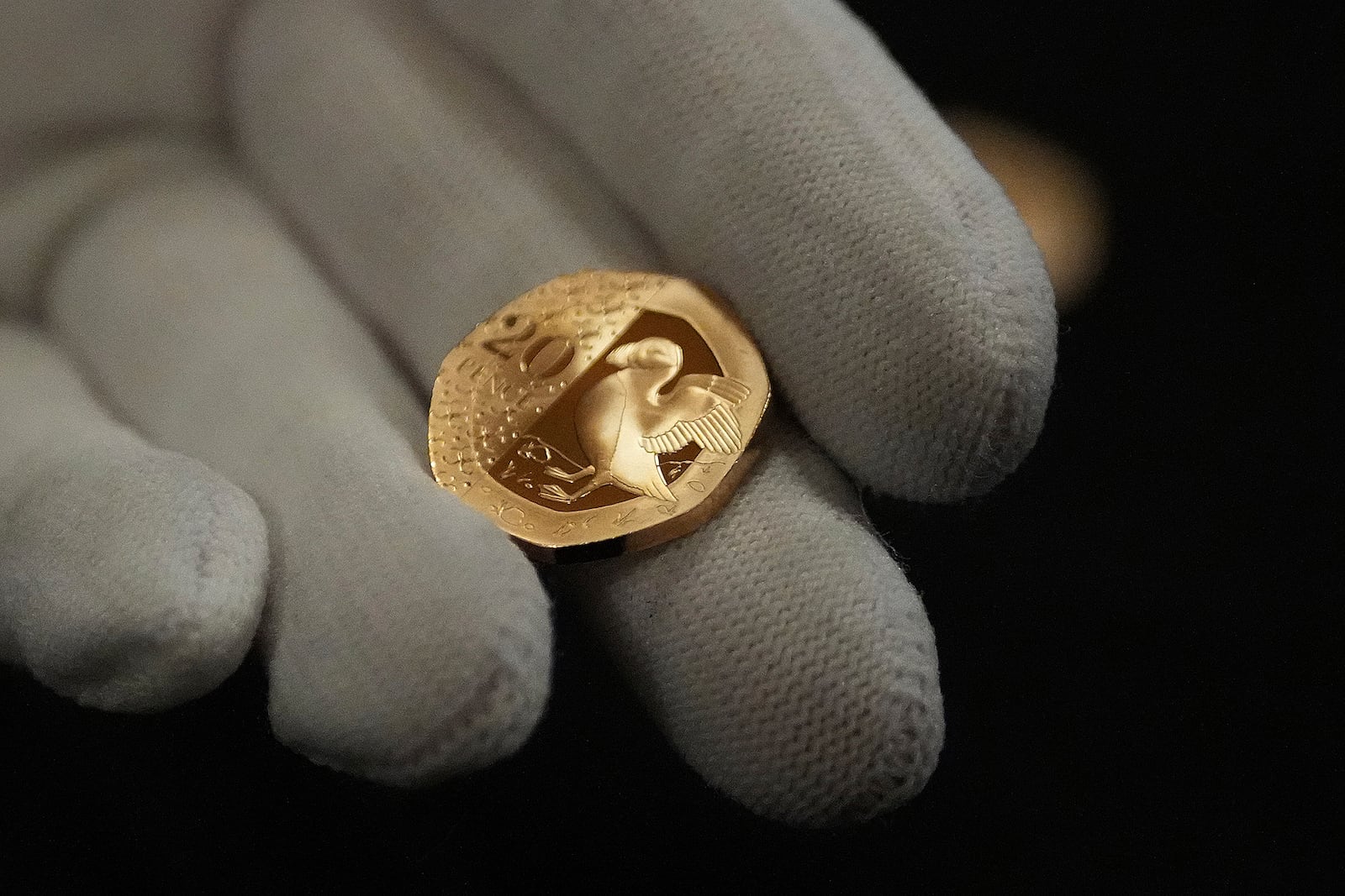 A 20 Pence commemorative coin is held by a warden during the "Trial of the Pyx,'' a ceremony that dates to the 12th Century in which coins are weighed in order to make certain they are up to standard, at the Goldsmiths' Hall in London, Tuesday, Feb. 11, 2025.(AP Photo/Frank Augstein)