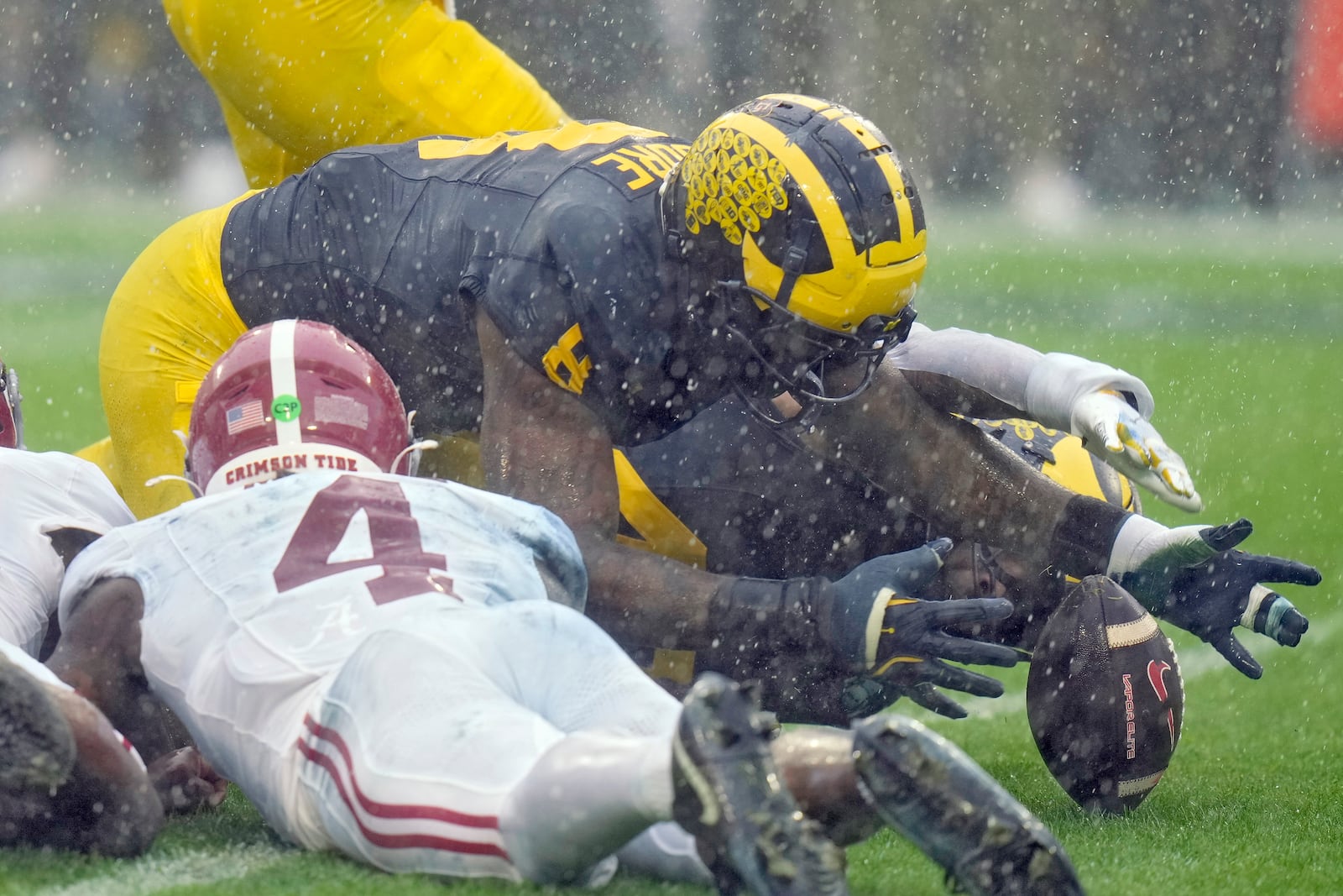 Michigan defensive end Derrick Moore (8) recovers a fumble by Alabama quarterback Jalen Milroe (4) during the first half of the ReliaQuest Bowl NCAA college football game Tuesday, Dec. 31, 2024, in Tampa, Fla. (AP Photo/Chris O'Meara)