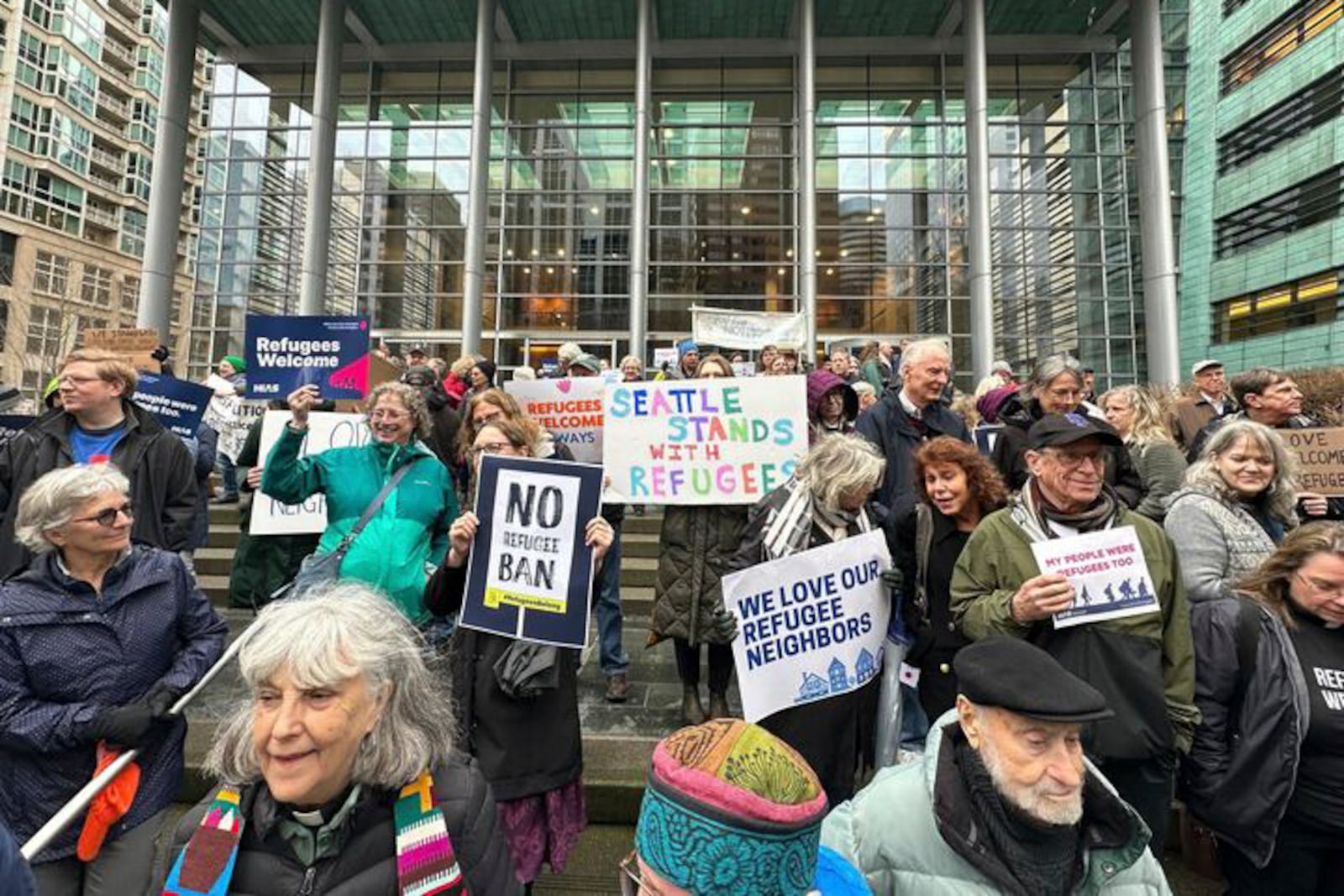 People gather outside the U.S. District Court after a federal judge blocked President Donald Trump's effort to halt the nation's refugee admissions system Tuesday, Feb. 25, 2025, in Seattle. (AP Photo/Eugene Johnson)