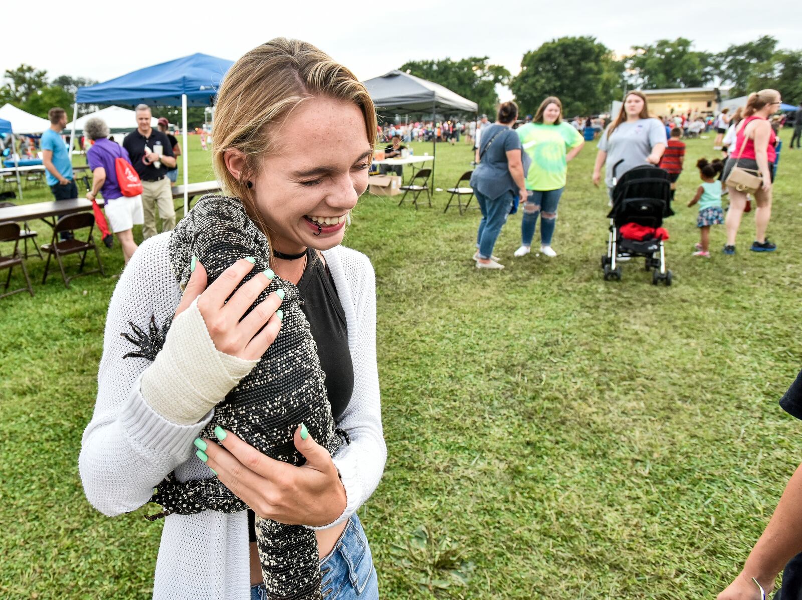 Crystal Kroener holds a black and white tegu named Cuddle Monster from Arrowhead Reptile Rescue during Middletown's National Night Out event Tuesday, Aug. 7 at Berachah Church in Middletown. NICK GRAHAM/STAFF