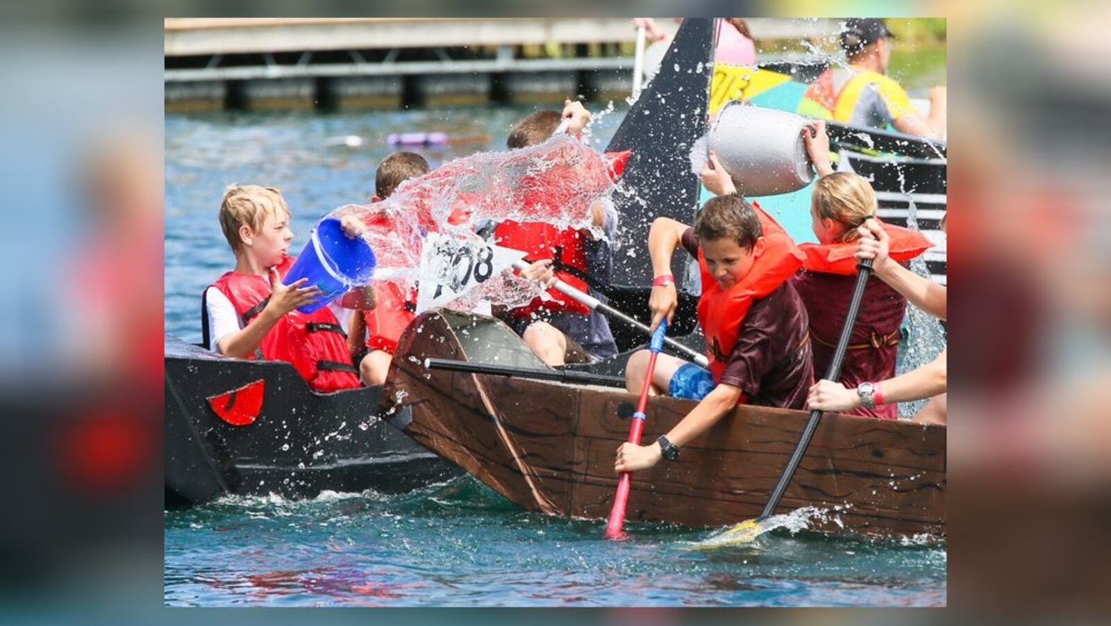 Several boats participated in a giant water battle during the 7th annual Crazy Cardboard Regatta at the Voice of America Metropark in West Chester in 2016. GREG LYNCH/STAFF/FILE