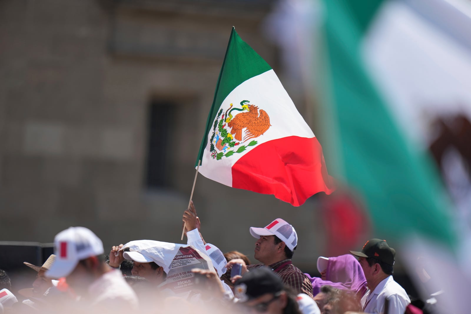 Supporters of President Claudia Sheinbaum attend a rally she convened to welcome U.S. President Donald Trump's decision to postpone tariffs on Mexican goods for one month at the Zocalo, Mexico City's main square, Sunday, March 9, 2025. (AP Photo/Eduardo Verdugo)