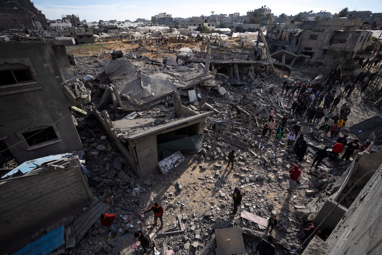 FILE - Palestinians inspect damaged residential buildings where two Israeli hostages were reportedly held before being rescued during an operation by Israeli security forces in Rafah, southern Gaza Strip, on Feb. 12, 2024. (AP Photo/Fatima Shbair, File)