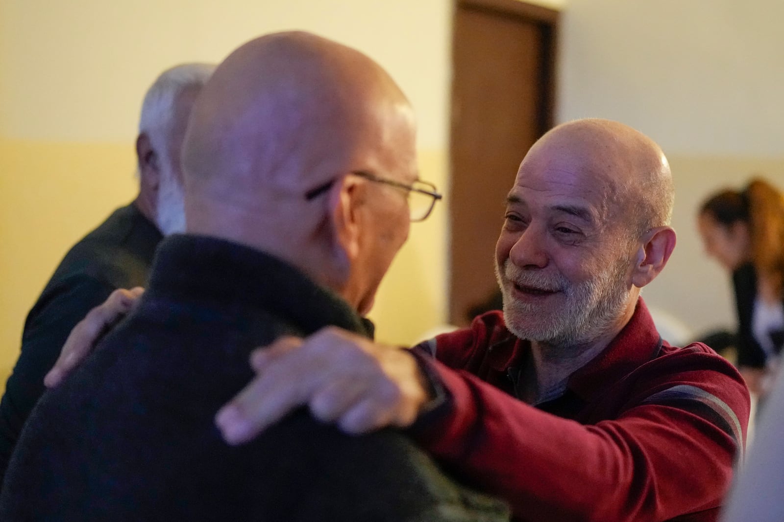 A neighbor welcomes Suheil Hamwi, right, who spent 32 years in prison in Syria, at Hamwi's home in Chekka, Lebanon, Tuesday, Dec. 10, 2024. (AP Photo/Hassan Ammar)