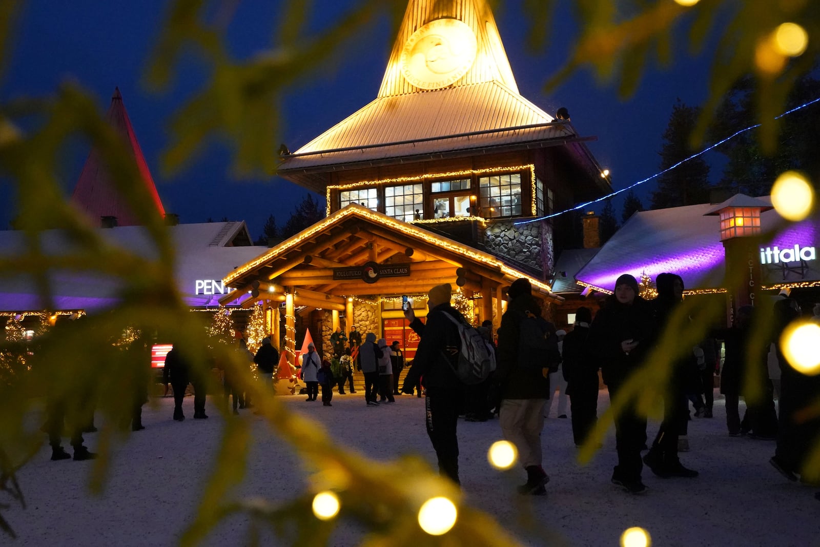 Tourists gather at Santa Claus Village, a winter-themed amusement park perched on the edge of the Arctic Circle, in Rovaniemi, Finland, Wednesday, Dec. 4, 2024. (AP Photo/James Brooks)