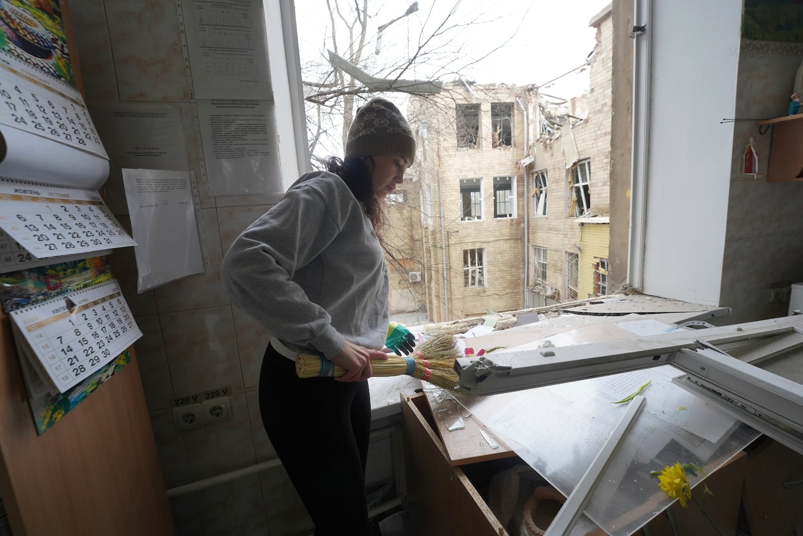 A medical worker sweeps up the glass shards in a hospital damaged by a Russian strike, in Kharkiv, Ukraine, Saturday, March 1, 2025. (AP Photo/Andrii Marienko)