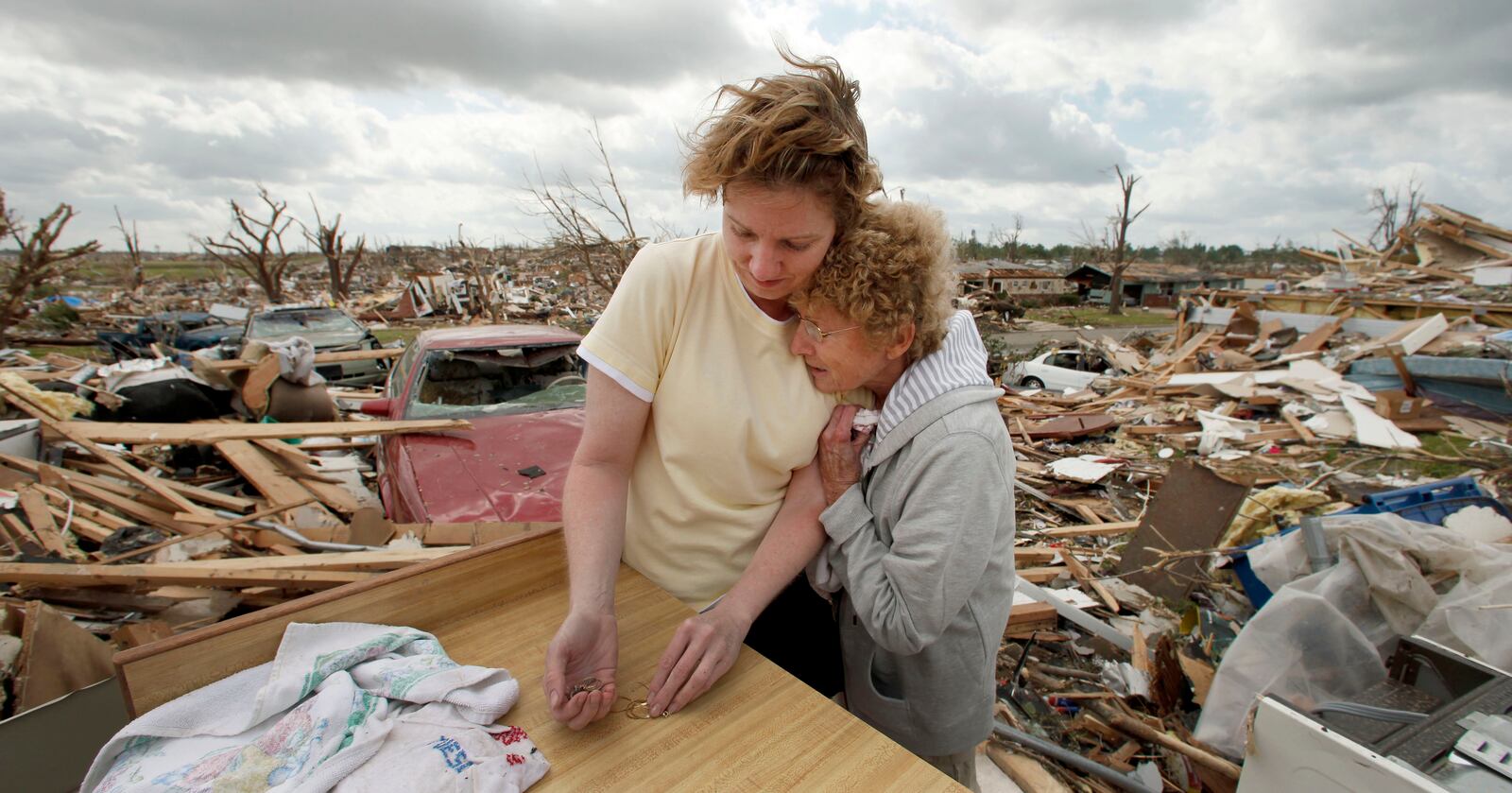 FILE- In this May 25, 2011 file photo, Beverly Winans hugs her daughter Debbie Surlin while salvaging items from Winans' devastated home in Joplin, Mo. (AP Photo/Charlie Riedel, file)