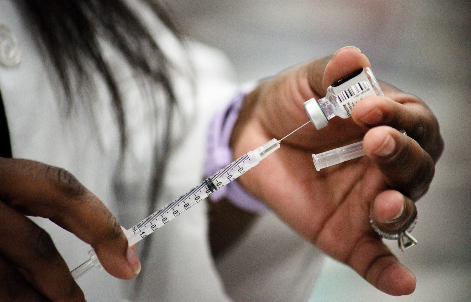 Kroger nurse practitioner Amanda Flowers prepares Covid-19 vaccines to be administered to school staff Wednesday, February 3, 2021 at Lakota West High School in West Chester Township. NICK GRAHAM / STAFF