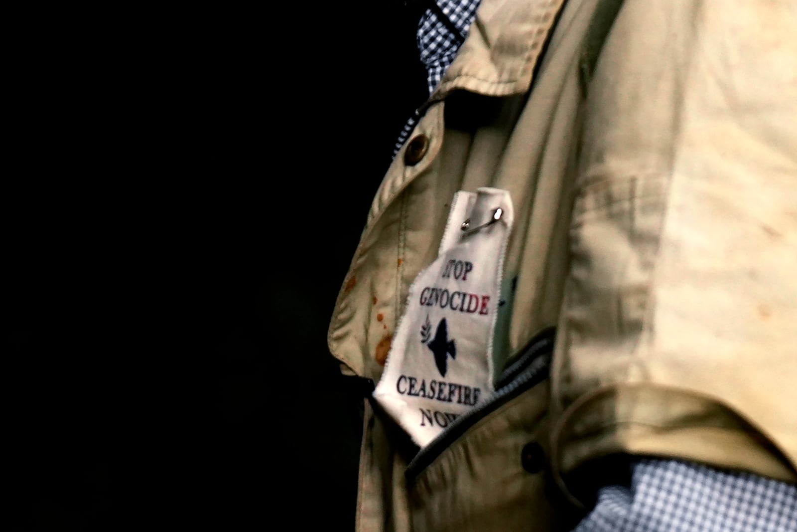 Takamatsu Gushiken wears a patch that reads "Stop Genocide, Ceasefire Now," outside a cave in Itoman, on the main island of the Okinawa archipelago, southern Japan, Sunday, Feb. 16, 2025. (AP Photo/Hiro Komae)