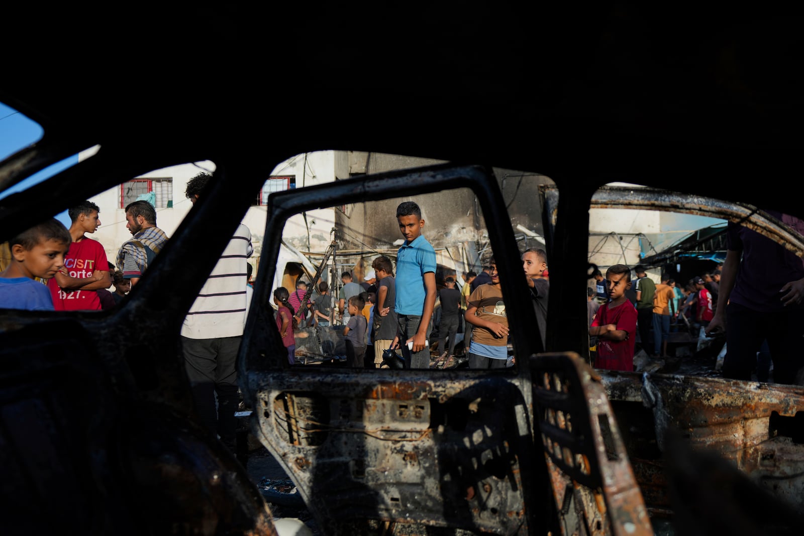 Palestinians look at the damage after an Israeli strike hit a tent area in the courtyard of Al Aqsa Martyrs hospital in Deir al Balah, Gaza Strip, Monday, Oct. 14, 2024. (AP Photo/Abdel Kareem Hana)