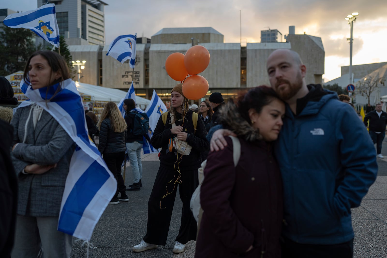 People gather during a vigil hours after the bodies of four Israeli hostages, Shiri Bibas, her two children, Ariel and Kfir, and Oded Lifshitz were handed over by Palestinian militant groups in Gaza to Israel, in Tel Aviv, Thursday, Feb. 20, 2025. (AP Photo/Ohad Zwigenberg)