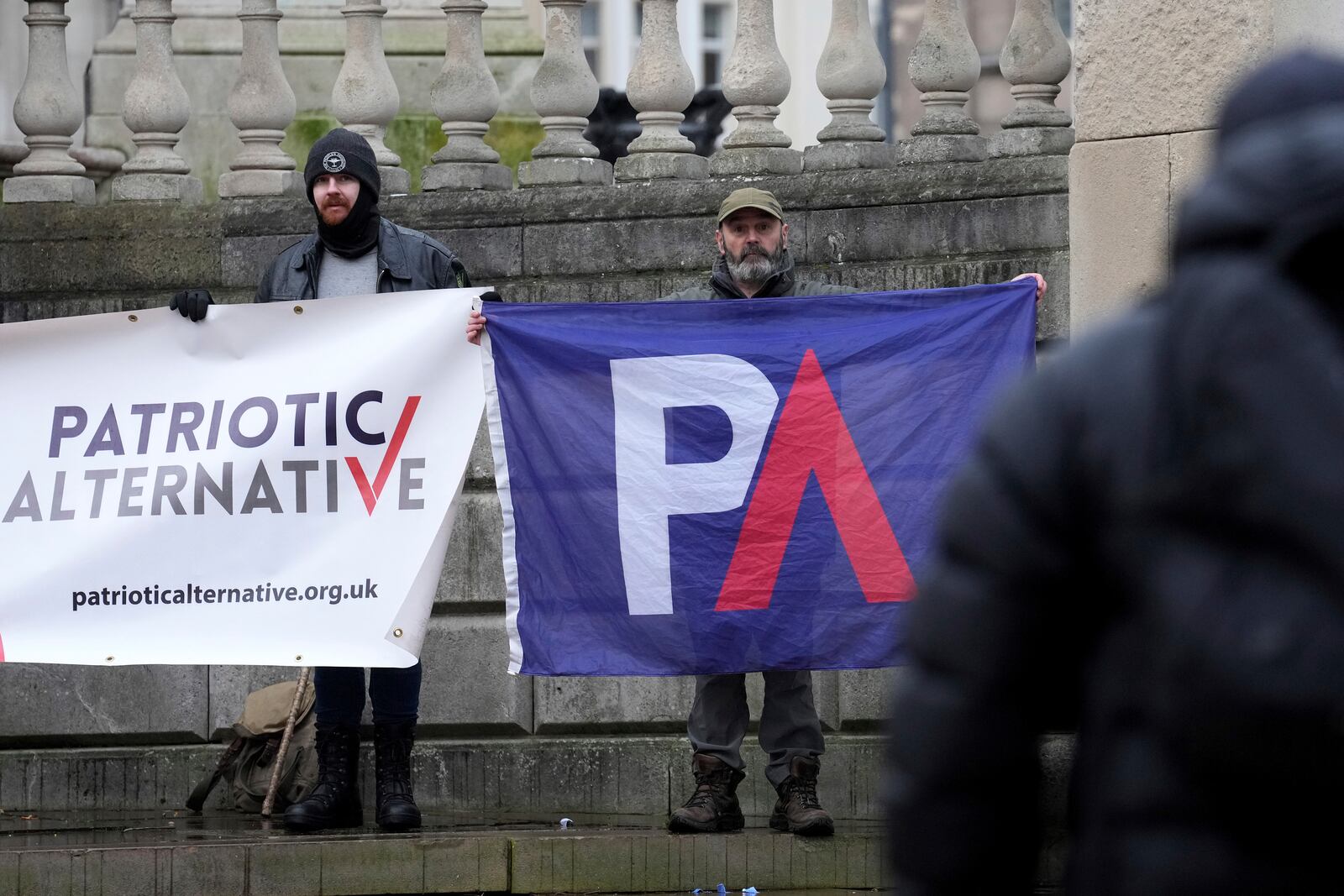 Protesters hold banners near Liverpool Crown Court in Liverpool, England, Monday, Jan. 20, 2025 where Axel Rudakubana is charged with killing three girls and wounding 10 other people in a stabbing rampage at a Taylor Swift-themed dance class in England last summer.(AP Photo/Jon Super)