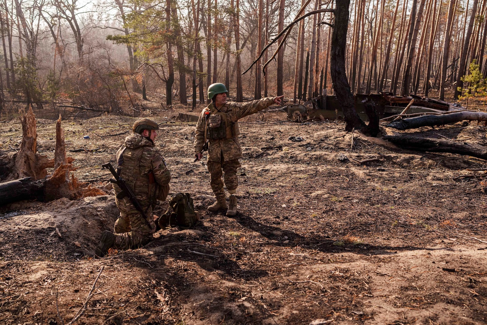 Andrii Serhieiev, right, a soldier with Ukraine's 53rd Brigade who lost a leg in combat, and another soldier install explosives near the front line in Ukraine's Donetsk region on Feb. 13, 2025. (AP Photo/Evgeniy Maloletka)