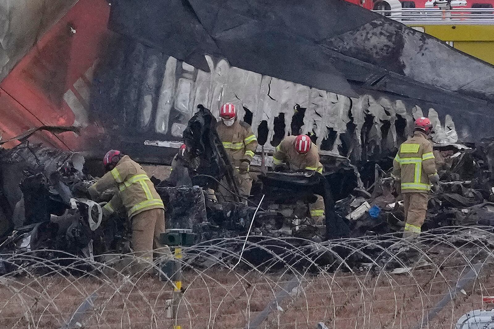 Rescue team members work at the site of a plane fire at Muan International Airport in Muan, South Korea, Monday, Dec. 30, 2024. (AP Photo/Ahn Young-joon)