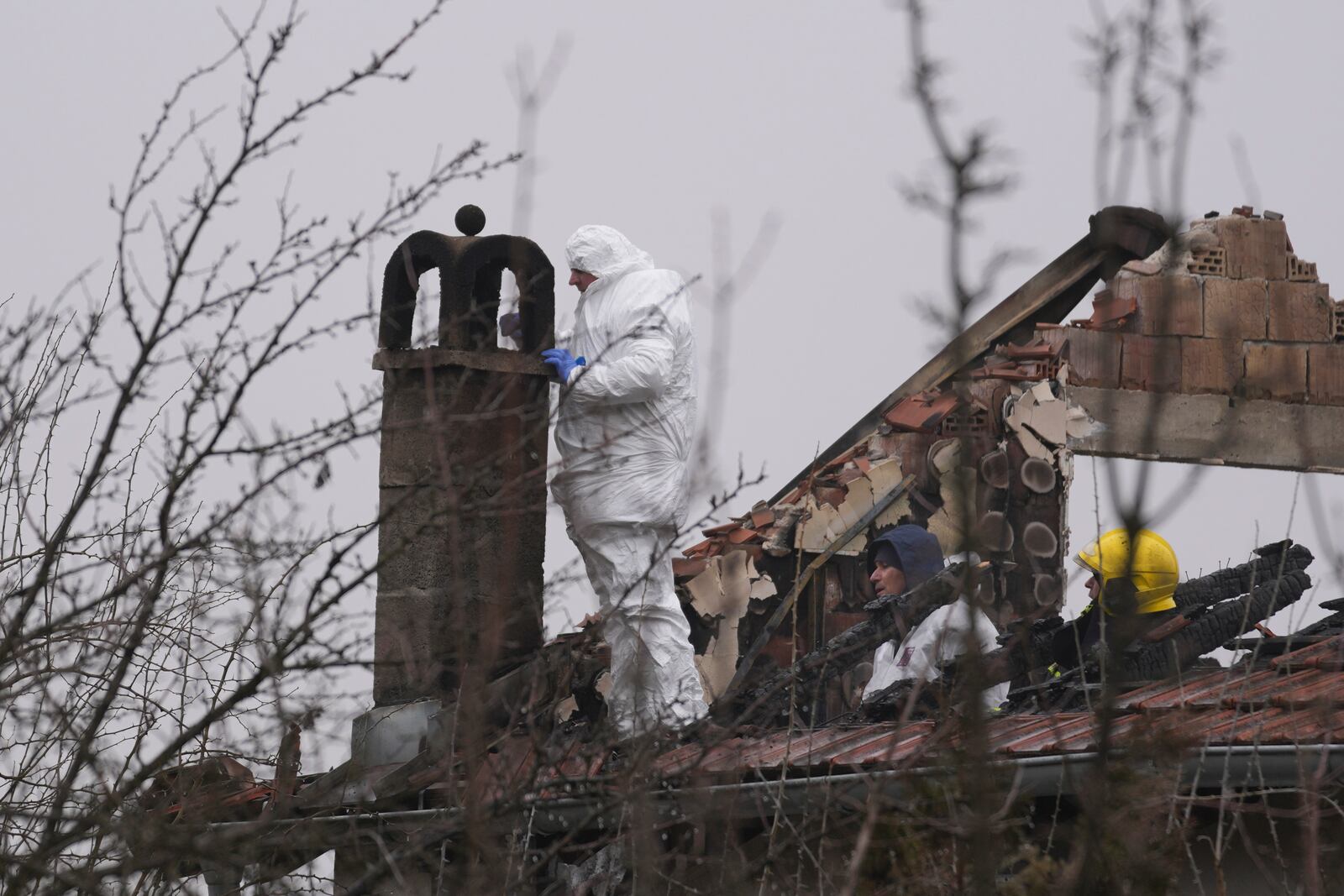 Police officers inspect a home for the elderly where eight people died in a fire, in Barajevo, a municipality of Belgrade, Serbia, Monday, Jan. 20, 2025. (AP Photo/Darko Vojinovic)