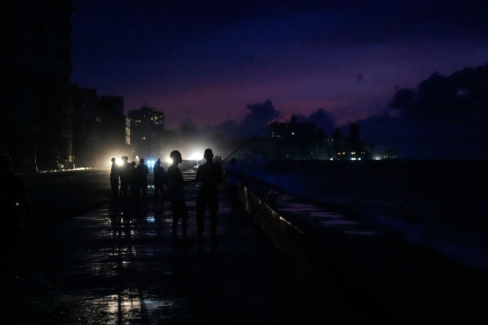 People mill about on the Malecon during a massive blackout after a major power plant failed in Havana, Cuba, Friday, Oct. 18, 2024. (AP Photo/Ramon Espinosa)