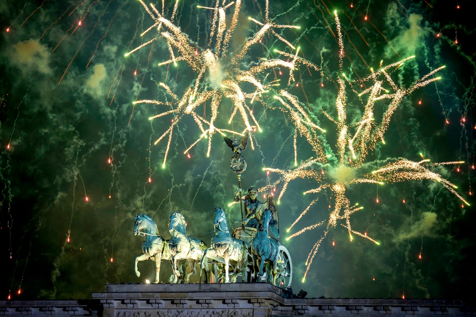 Fireworks light the sky above the Quadriga at the Brandenburg Gate during New Year's celebrations shortly after midnight in Berlin, Germany, Wednesday, Jan. 1, 2025. (AP Photo/Ebrahim Noroozi)