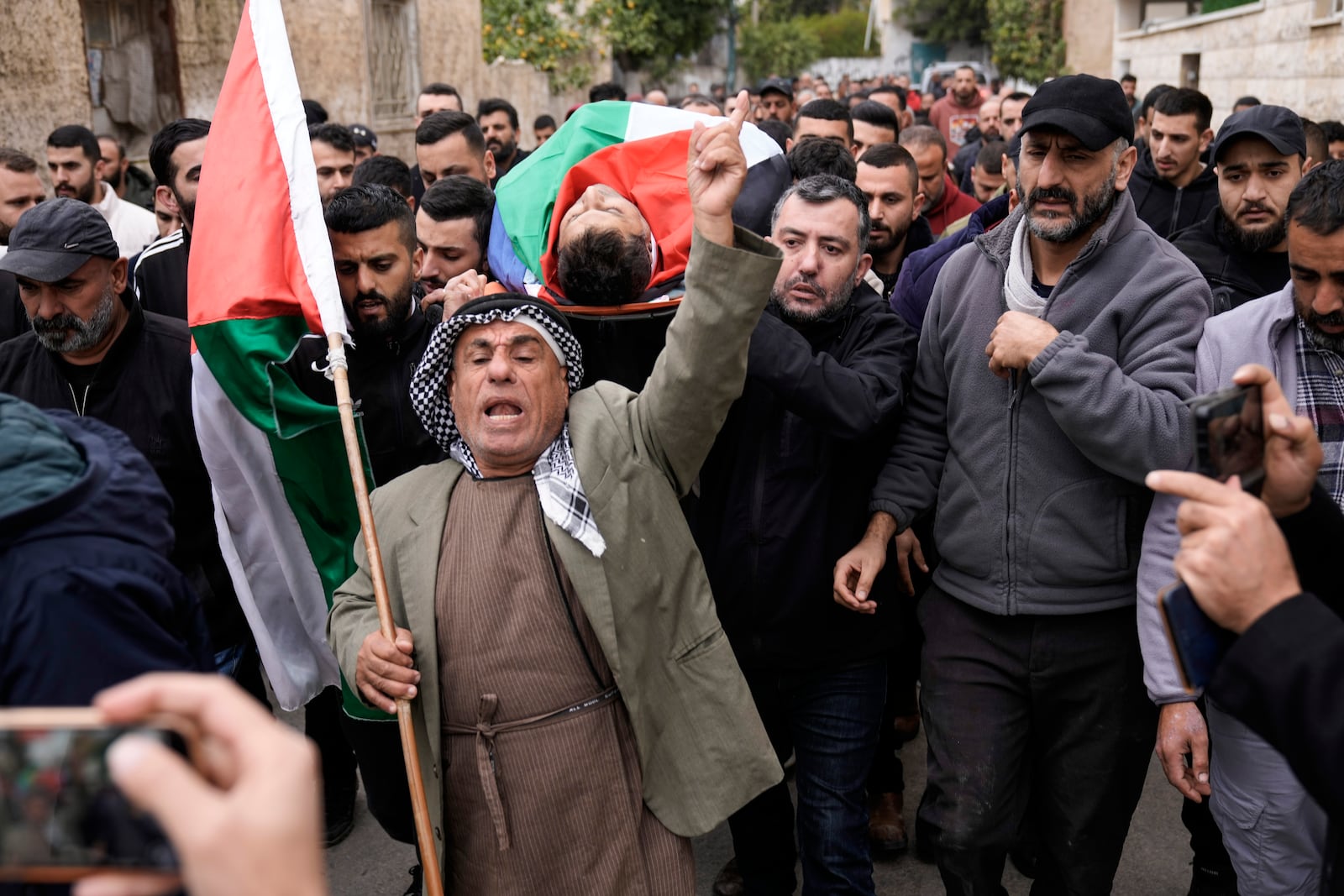 Mourners carry the body of Ahmad Nimer Al-Shaib after he was killed during an Israeli military operation in Jenin, in the West Bank village of Bruqin, Wednesday, Jan. 22, 2025. (AP Photo/Majdi Mohammed)