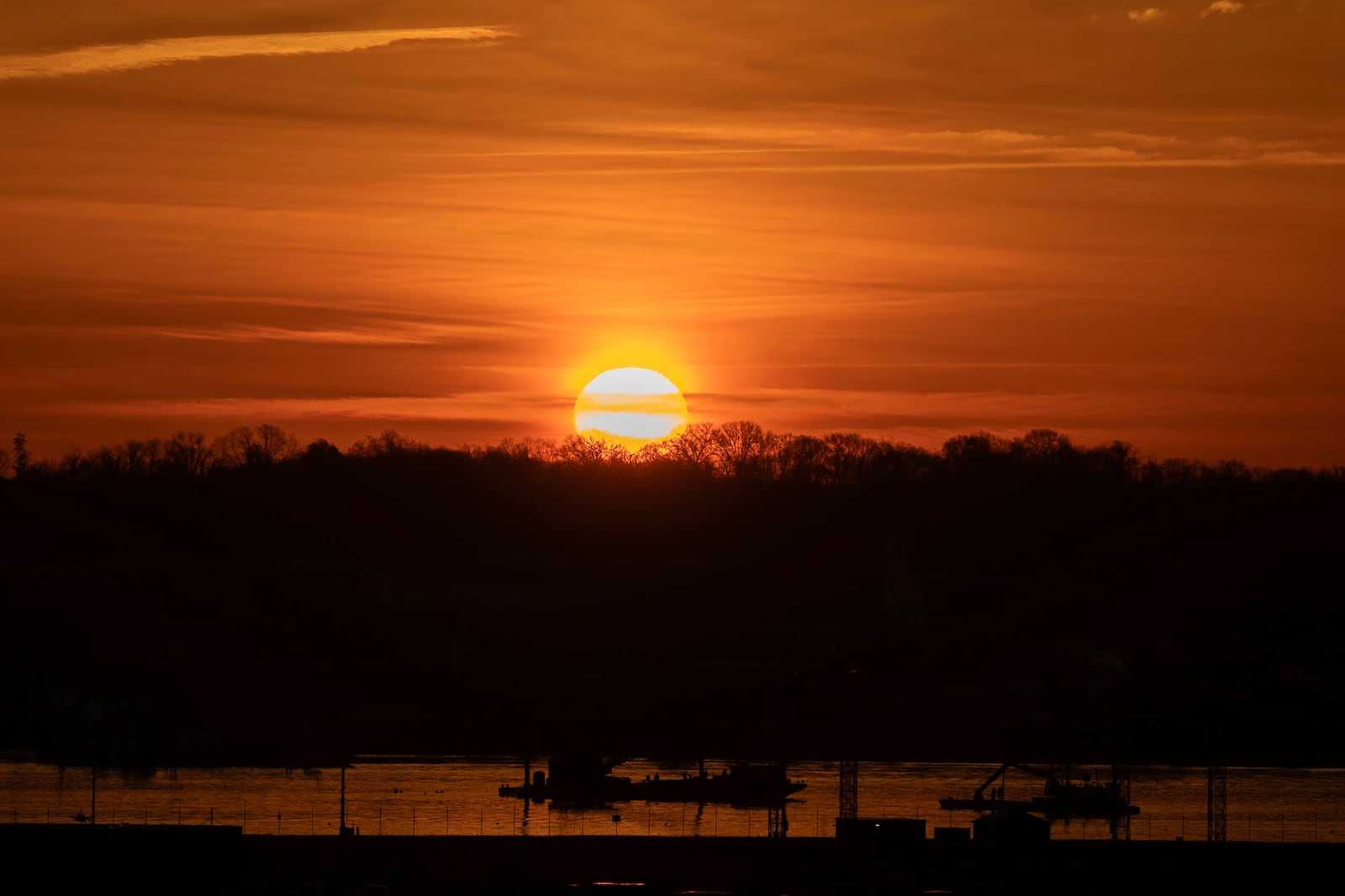 The sun rises above a wreckage site in the Potomac River across from Ronald Reagan Washington National Airport, Monday, Feb. 3, 2025, in Arlington, Va. (AP Photo/Jose Luis Magana)