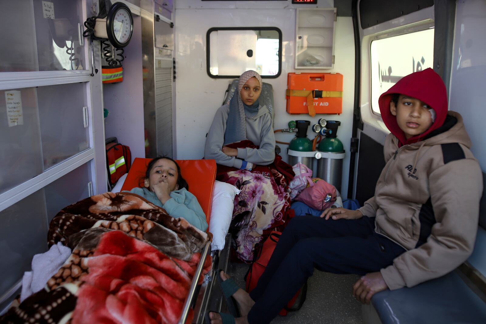 Palestinians wounded in the Israeli bombardment of the Gaza Strip wait inside an ambulance before crossing the Rafah border into Egypt, as wounded and sick Palestinians are allowed to leave the Gaza Strip for medical treatment, in Khan Younis, Saturday Feb. 1, 2025. (AP Photo/Jehad Alshrafi)