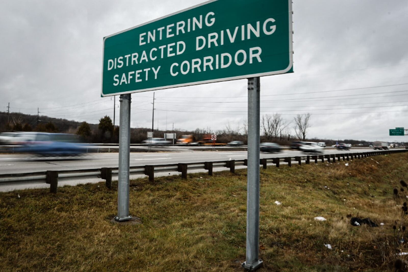 A large sign on the northbound side of Interstate 75 near West Carrollton warns drivers they are entering a distracted driving safety corridor.  Gov. Mike DeWine signed a bill limiting the use of electronic devices while driving. JIM NOELKER/STAFF