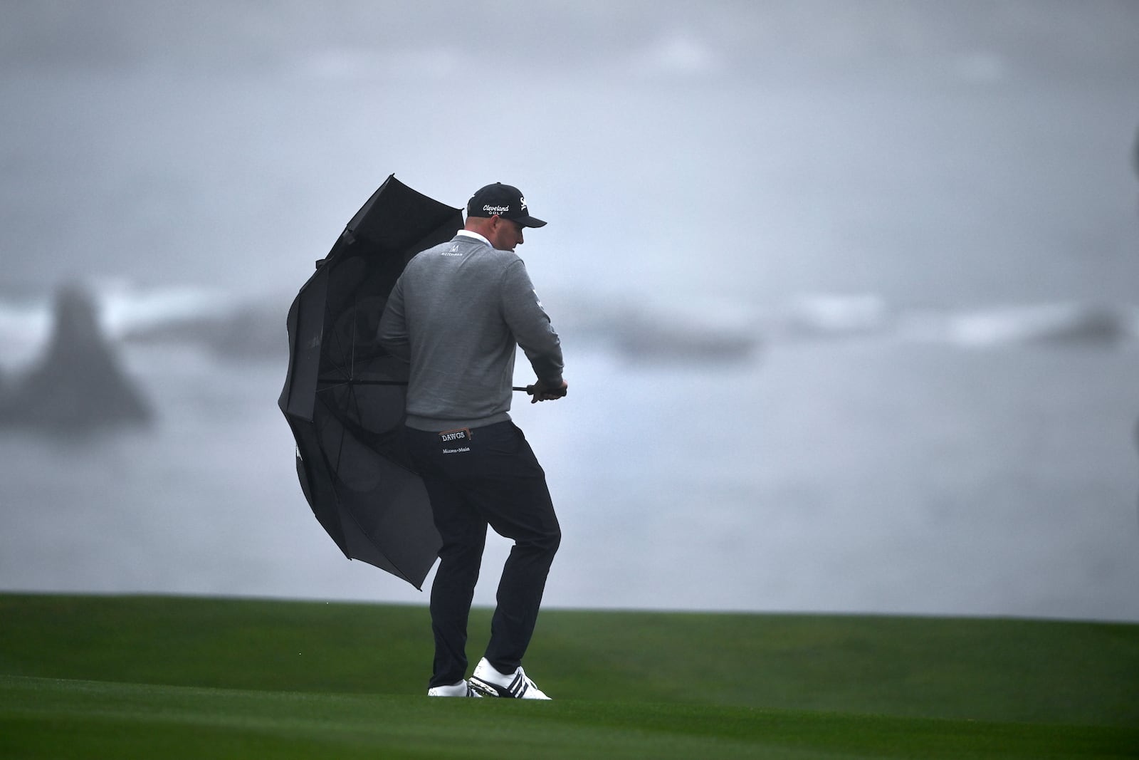 Sepp Straka, of Austria, walks with an umbrella on the sixth hole at Pebble Beach Golf Links during the third round of the AT&T Pebble Beach Pro-Am golf tournament, Saturday, Feb. 1, 2025, in Pebble Beach, Calif. (AP Photo/Nic Coury)