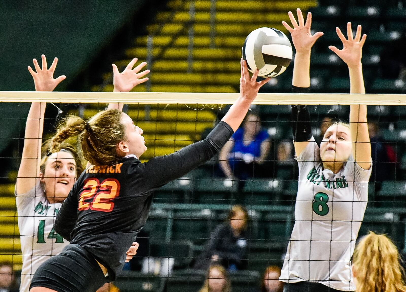 Fenwick’s Emma Schaefer attempts to get ball past Parma Heights Holy Name’s Zelie Kessler (8) on Friday during a Division II state volleyball semifinal at Wright State University’s Nutter Center. NICK GRAHAM/STAFF