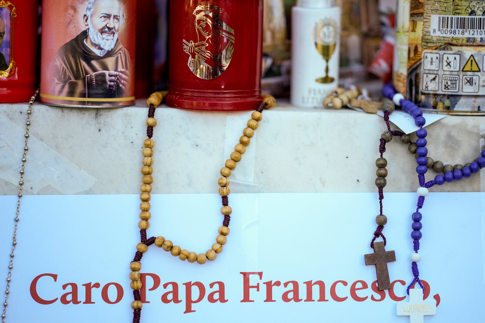 Candles and rosaries for Pope Francis are seen in front of the Agostino Gemelli Polyclinic, in Rome, Tuesday, March 18, 2025, where the Pontiff is hospitalized since Feb. 14. (AP Photo/Andrew Medichini)