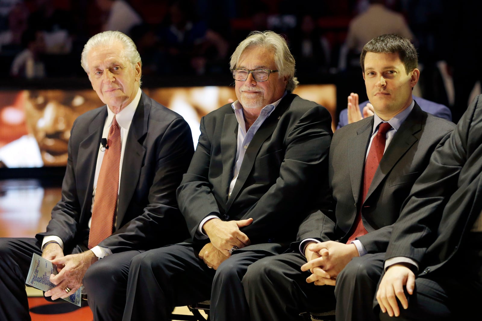 FILE - Miami Heat president Pat Riley, left, Micky Arison, team owner, center, and Nick Arison, team CEO, during Hall of Fame basketball player Shaquille O'Neal's jersey retirement ceremony at halftime at an NBA basketball game between the Los Angeles Lakers and the Miami Heat, Thursday, Dec. 22, 2016, in Miami. (AP Photo/Alan Diaz, File)